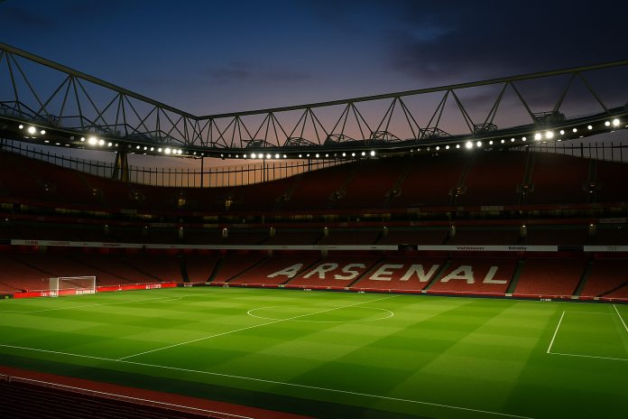 Speltips Arsenal Newcastle – fotorealistisk bild av Emirates Stadium i kvällsljus