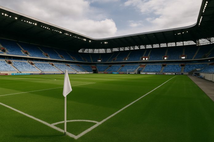 En tom fotbollsarena i Slovakien där matcher i U21 EM 2025 ska spelas, sedd från hörnflaggan med blå sittplatser runt om.